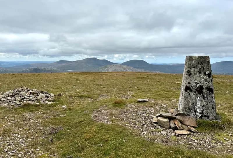 CLOUD AND CLEAR: Looking from the cairn and trig on summit of Corserine over to the Merrick hills