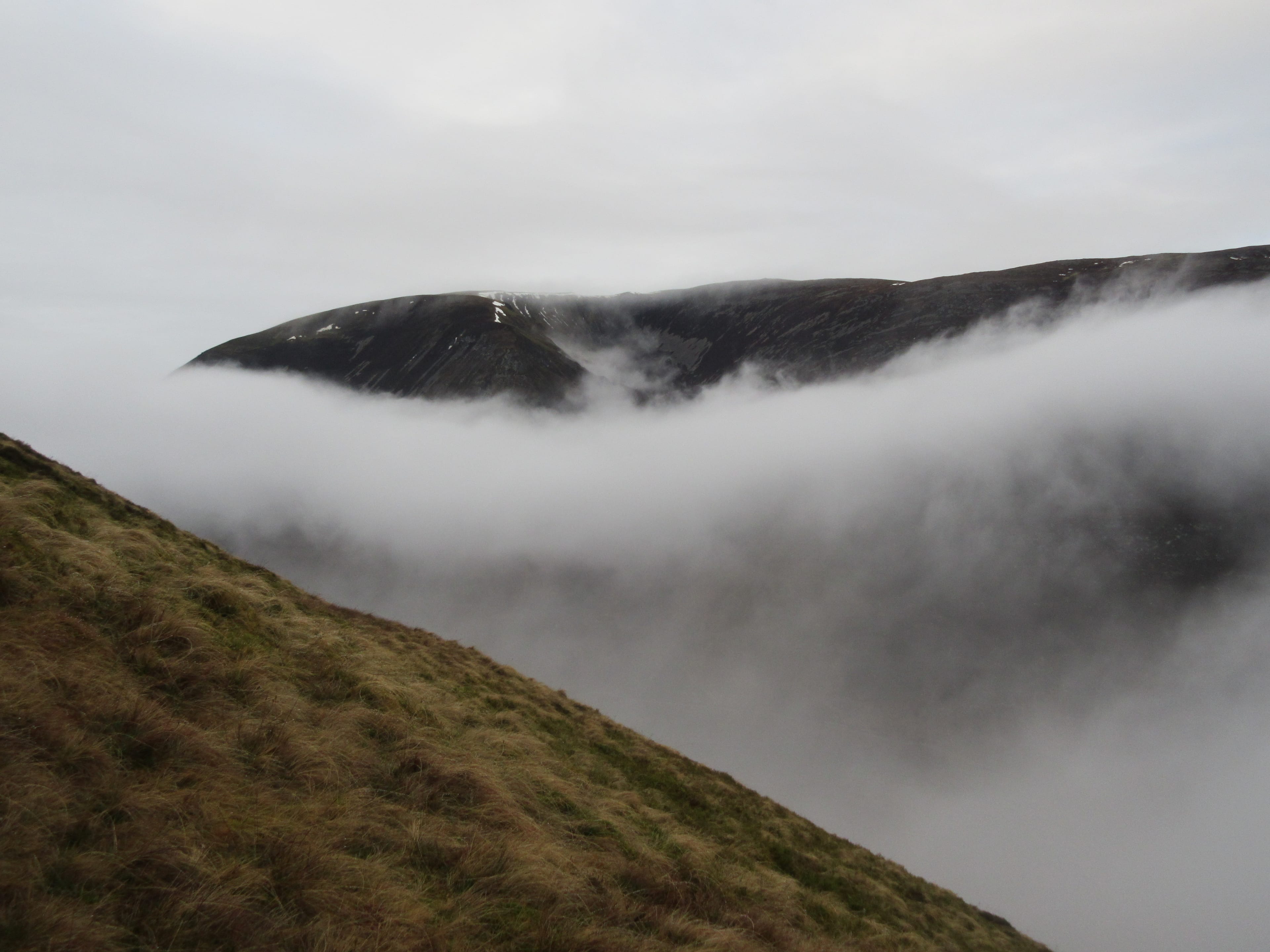 ROLLING AND TUMBLING: The shifting mist gives a brief glimpse of Beinn Iaruinn's summit ridge during the climb up Leanna Mhor