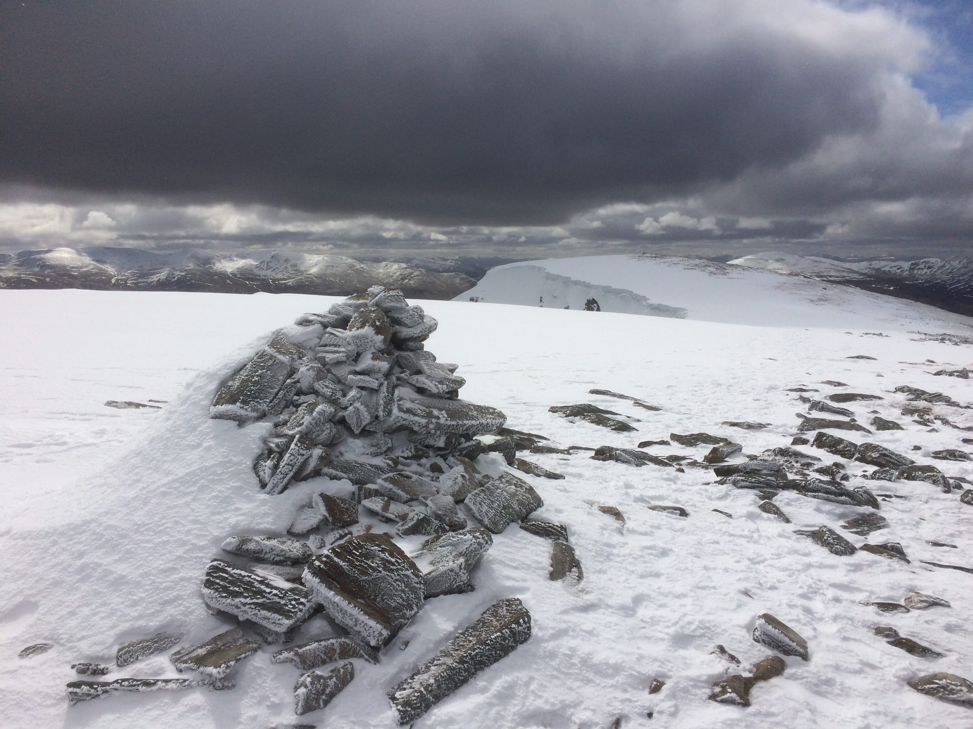 SNOWSCAPE: Threatening black skies loom over a frozen landscape from summit cairn of Beinn a'Chaorainn