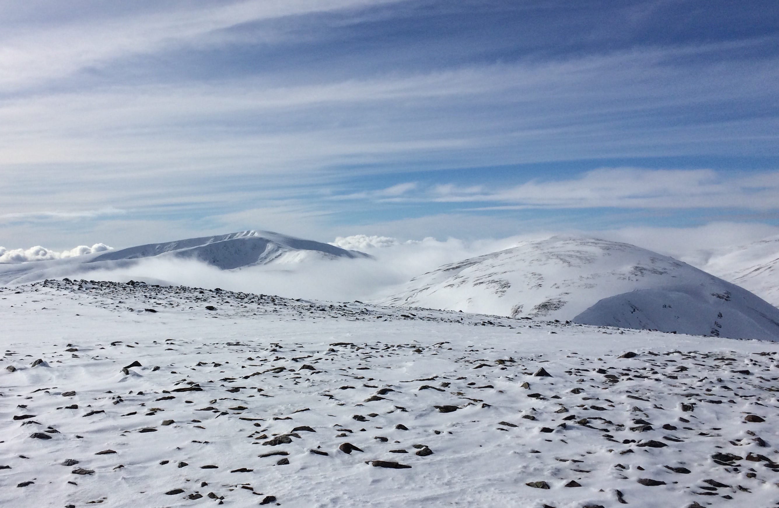 SO NEAR, SO FAR: Glas Tulaichean pushing up through the clouds in the distance during a winter trek in Glenshee