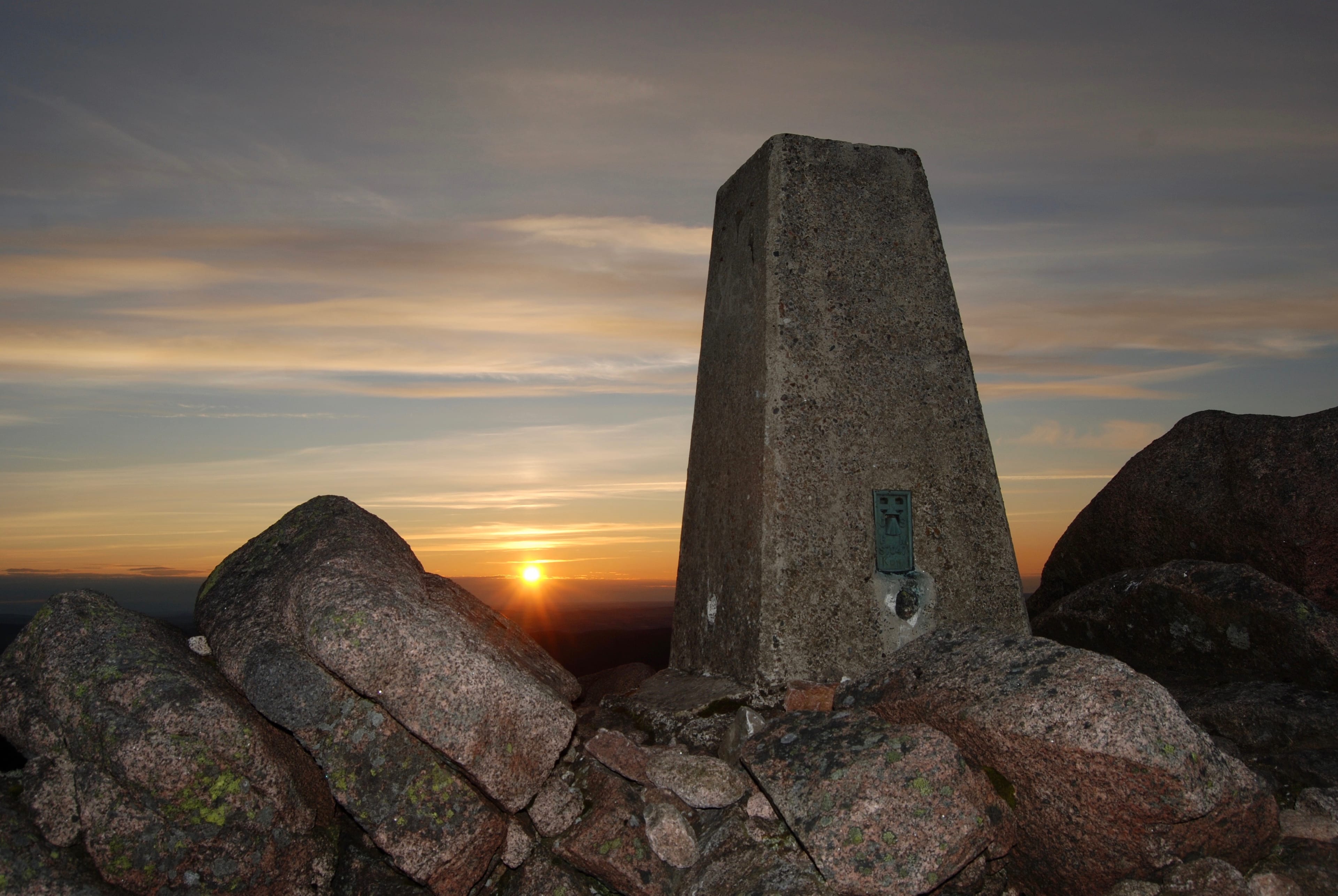 GOOD MORNING: The trig pillar on Mount Keen is centre stage as the sun bursts through on the distant horizon