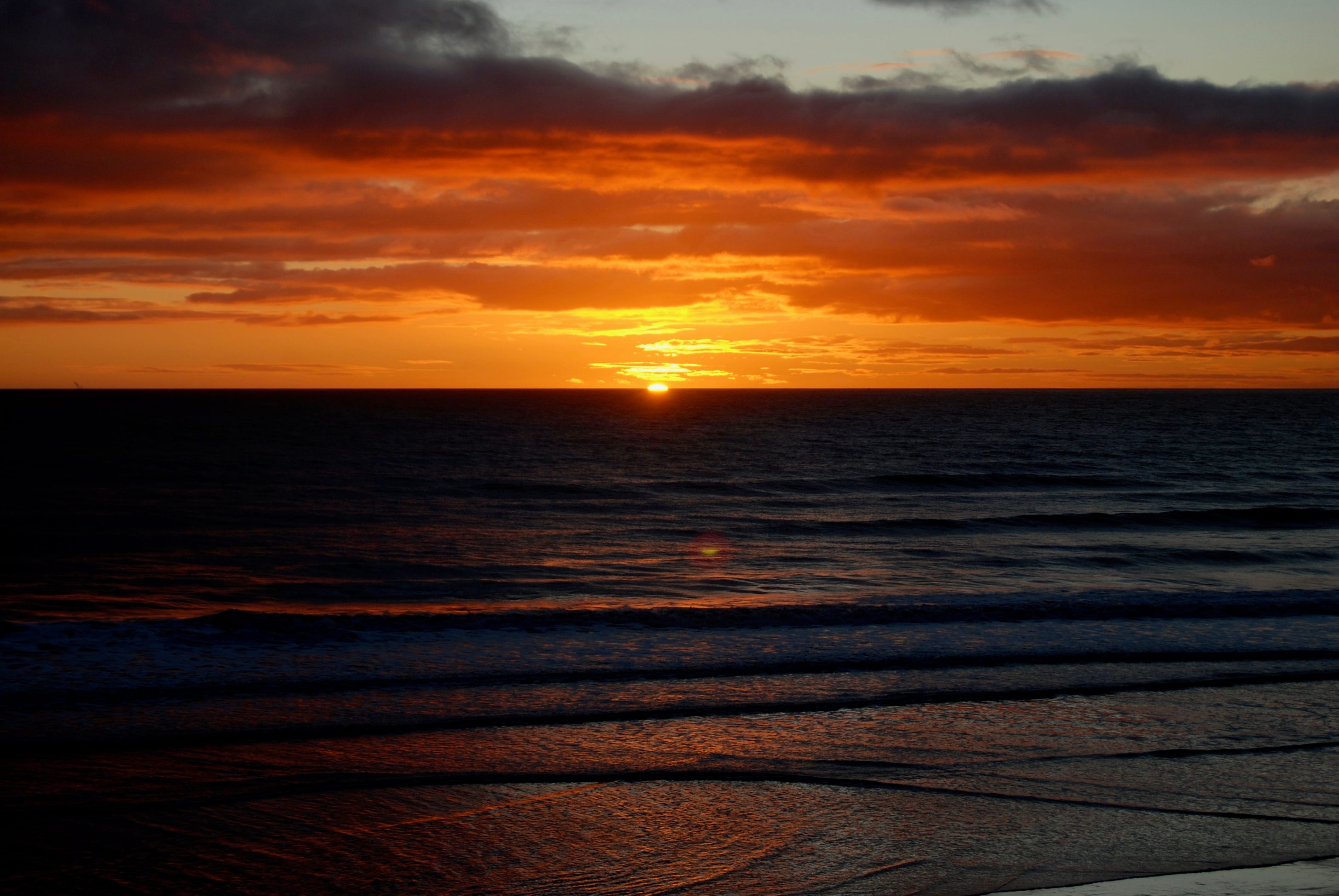 DARK SUNRISE: Rolling waves and sandy shores remain in shadow as the sun rises on a dark December morning