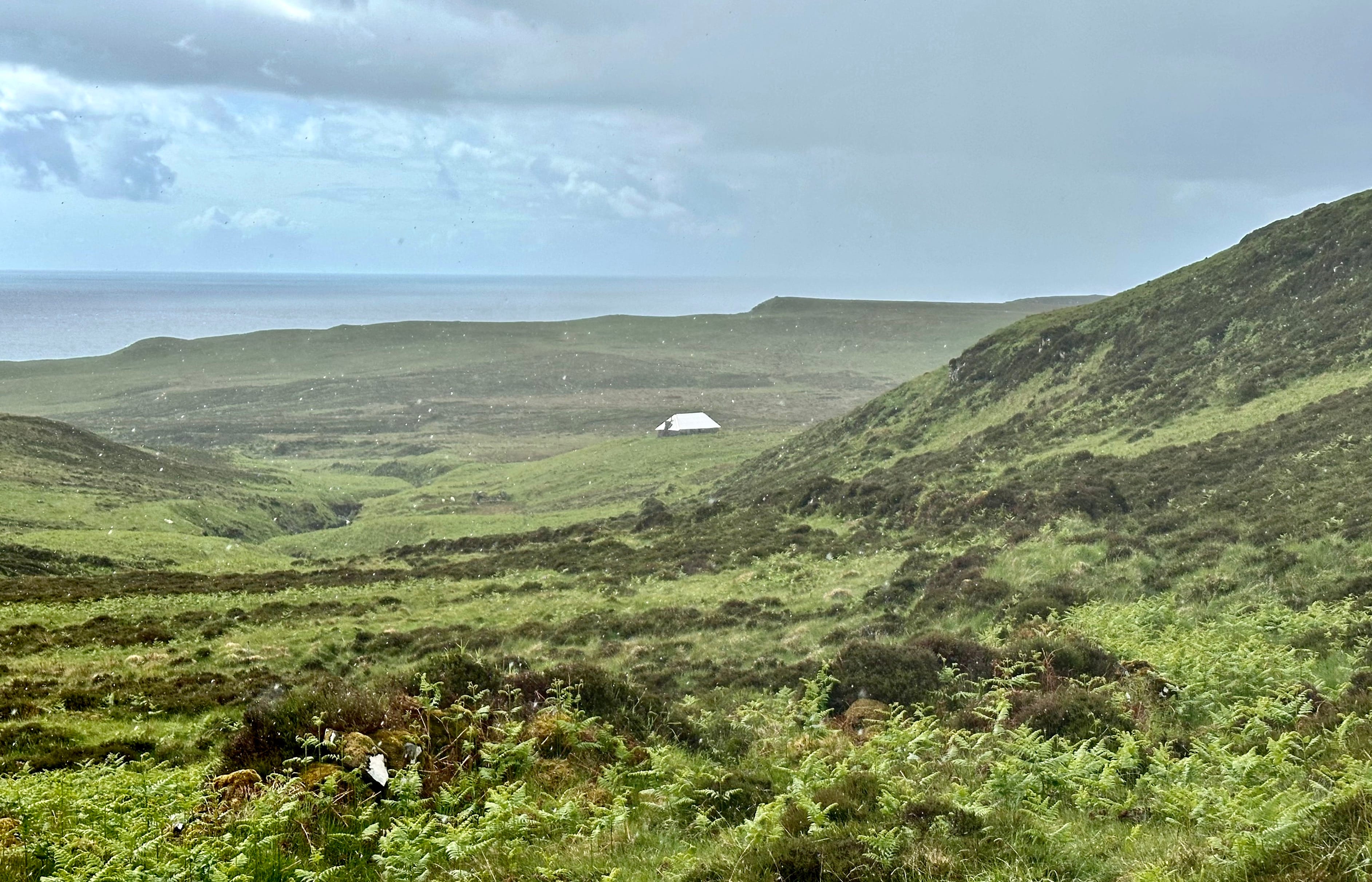 WELCOME HOME: The pale roof of lonely Ollisdal bothy stands out in the greenery on the descent of Coire Mor in the rain