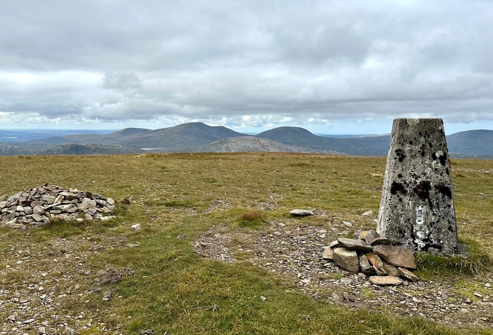 CLOUD AND CLEAR: Looking from the cairn and trig on summit of Corserine over to the Merrick hills